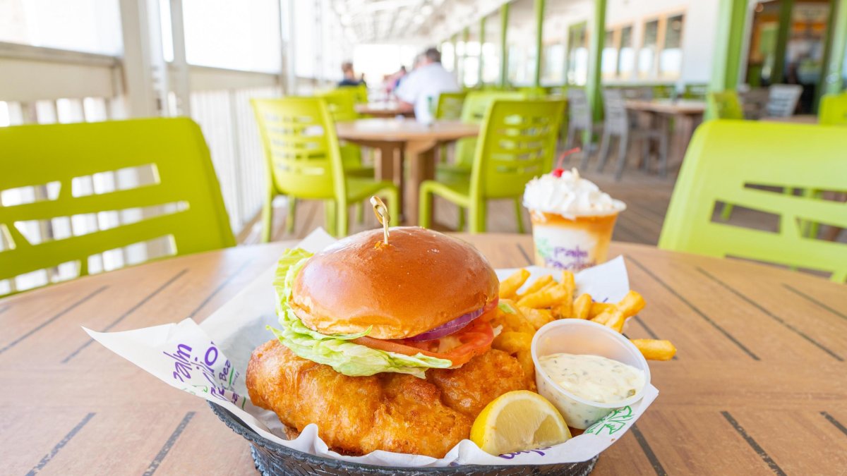 a fried grouper sandwich on a brioche bun with tartar sauce and a lemon