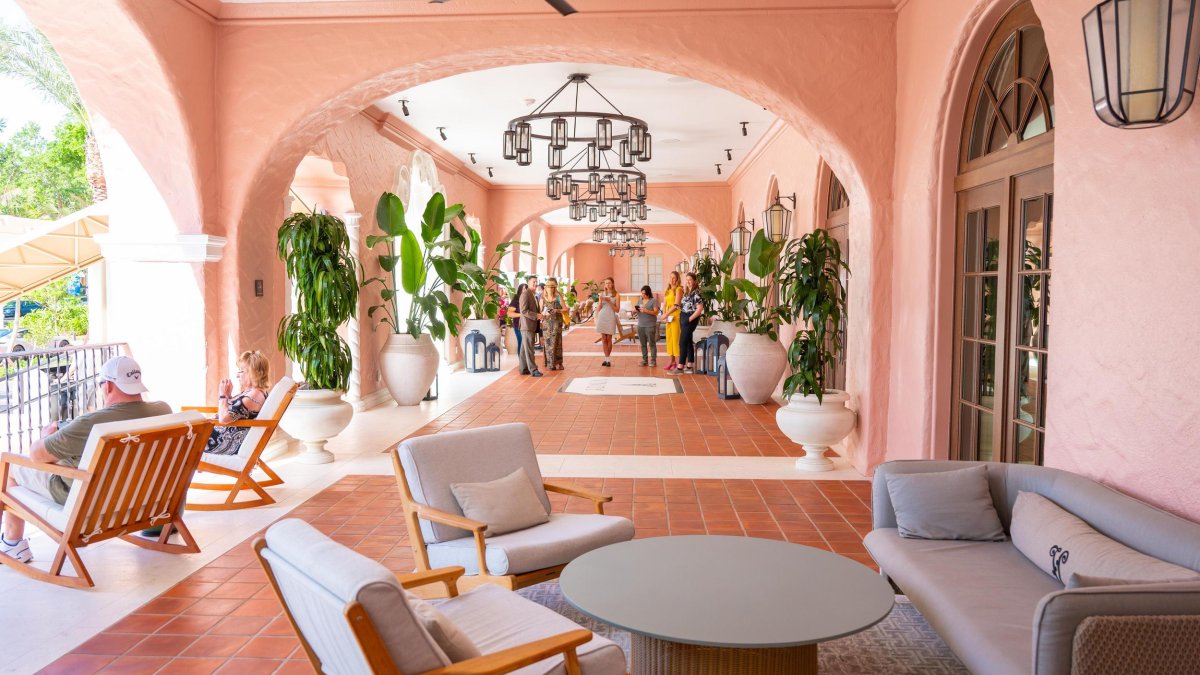 shaded pink patio with chandeliers and fans couches chairs and plants at the Vinoy Hotel