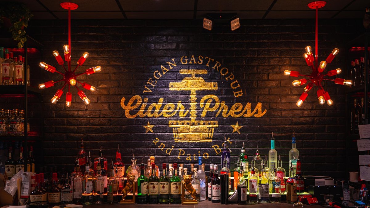 Bar with mood lighting and sign at Cider Press Vegan Gastropub