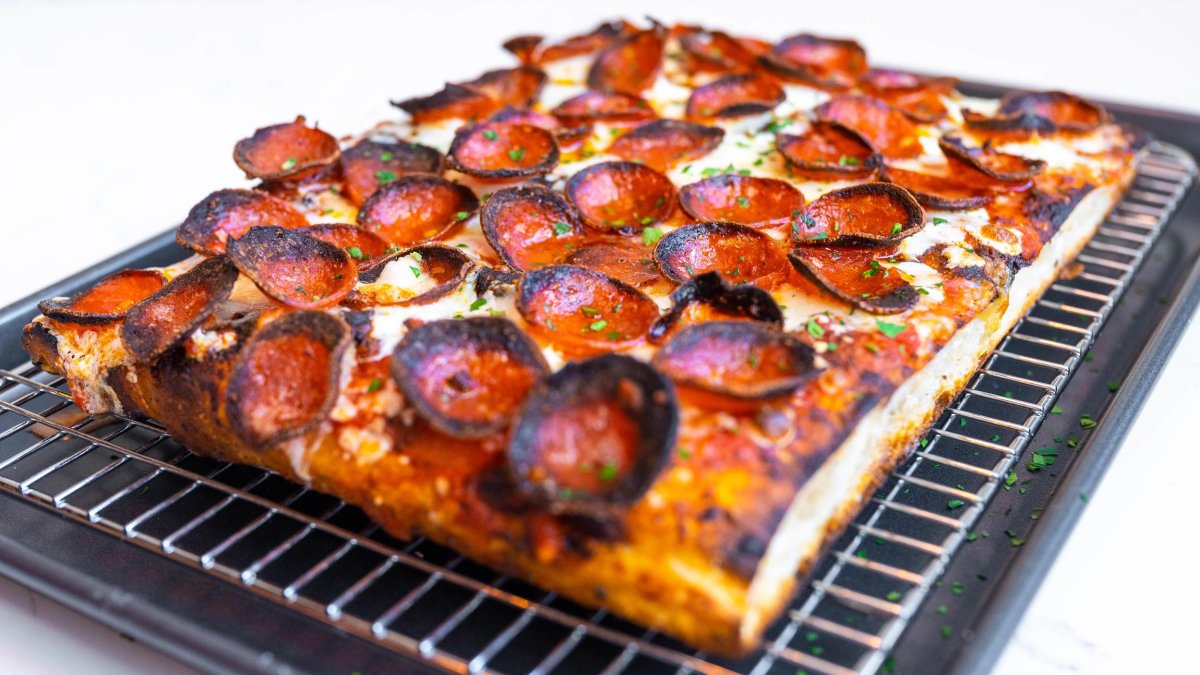 A square, thick-crust pizza with charred pepperoni