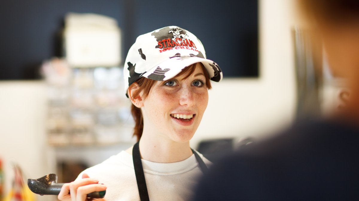 Ice cream shop employee serves a customer