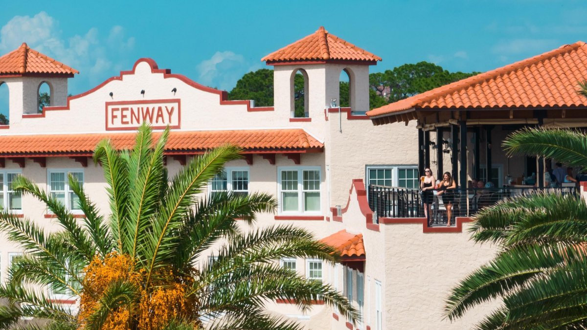 The Fenway Hotel with girls on balcony with palm trees, Dunedin Florida