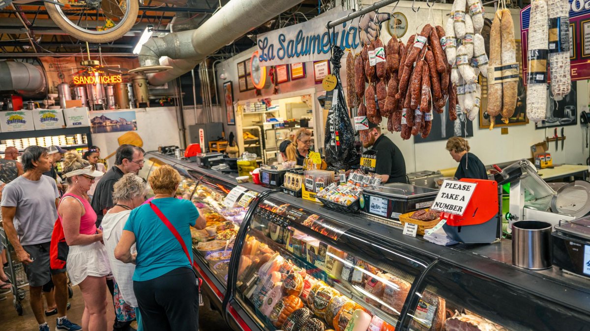 people stand in front of a deli counter at Mazzaro's Market in St. Pete