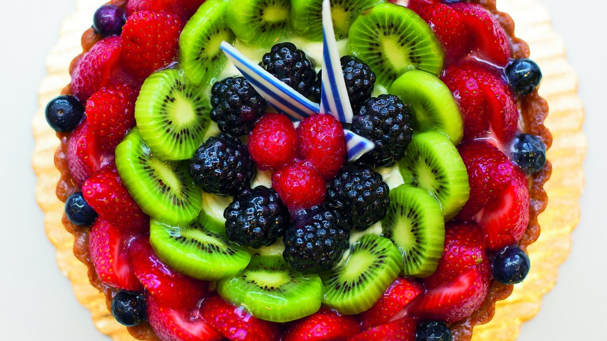 A colorful fruit pie made with berries and kiwi pieces.