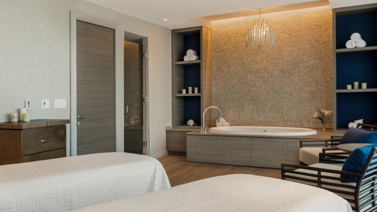 Couples spa treatment room with tub and massage tables