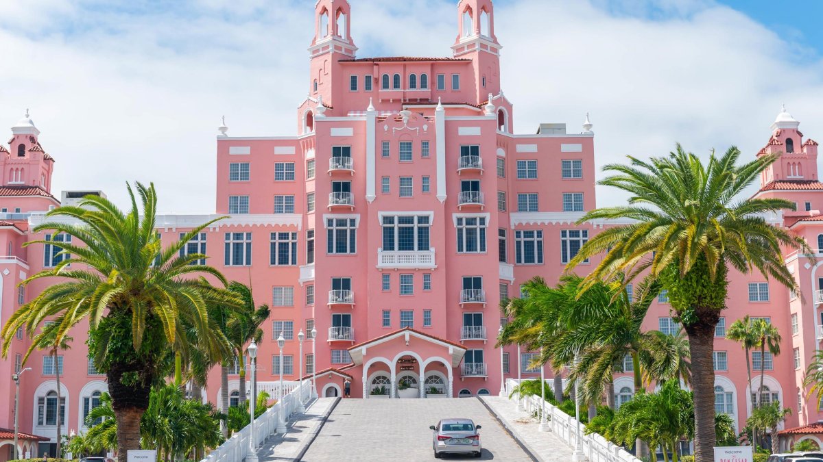 exterior of the historic don cesar hotel which looks like a bright pink castle with palm trees around it