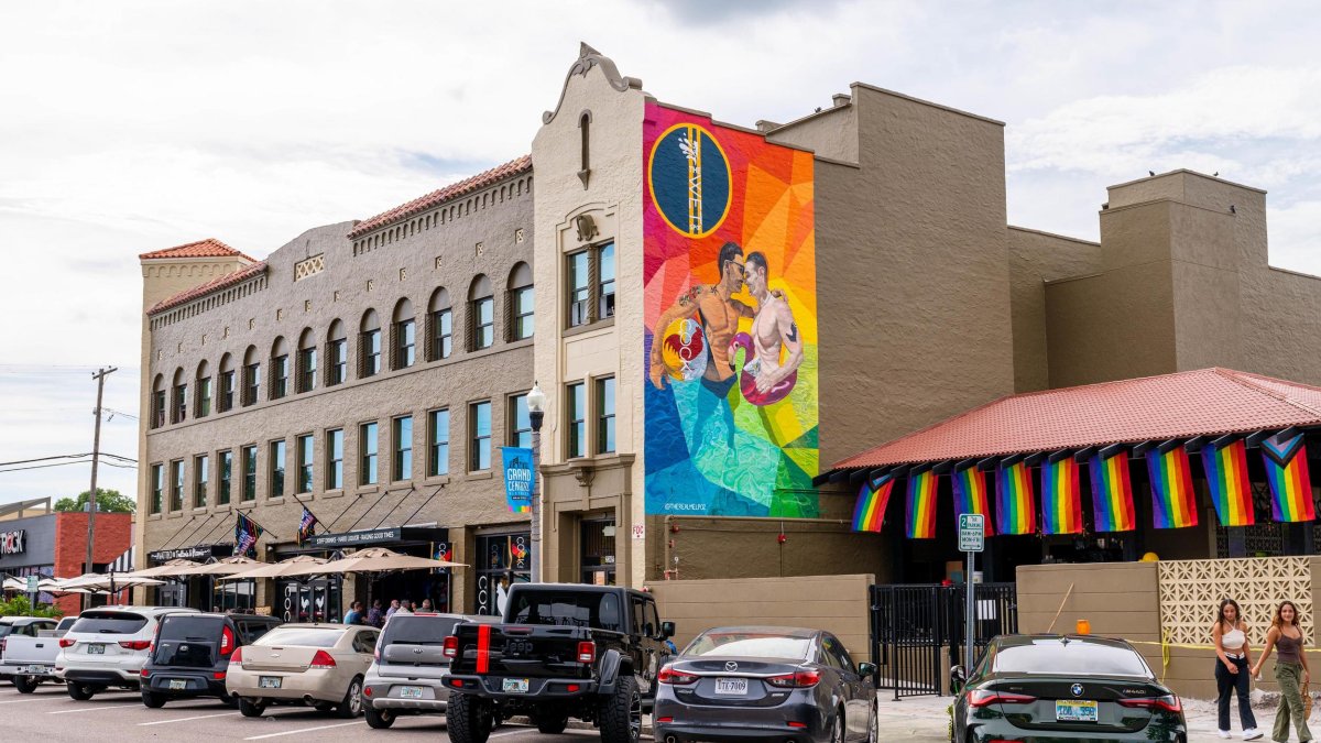 exterior of Mari Jean Hotel with vibrant mural of gay men and cocktail bar and pool bar