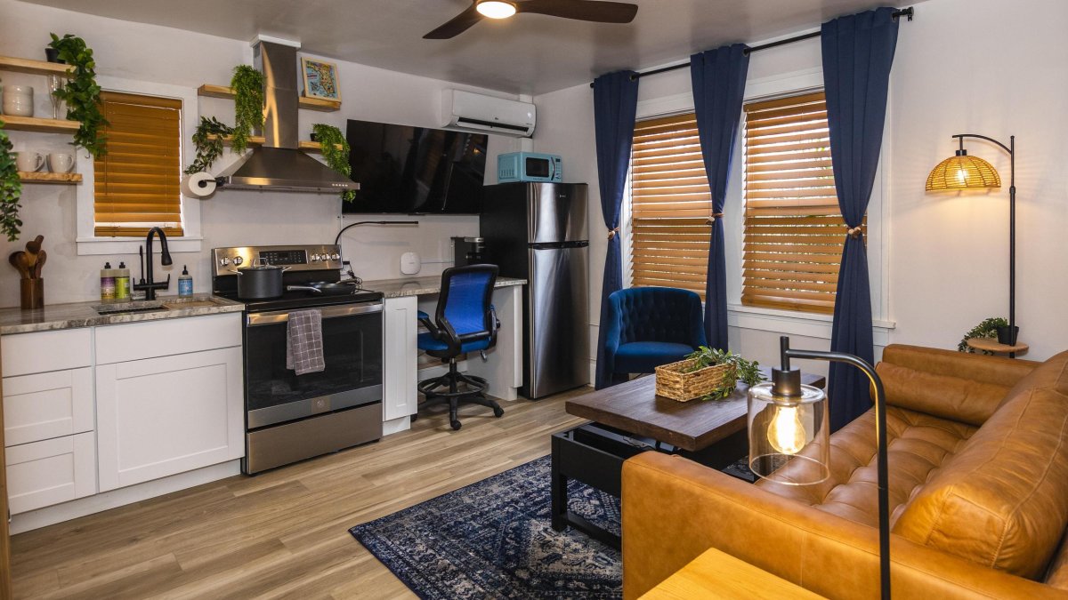 part of a hotel suite showing a kitchenette, work space and couch and coffee table