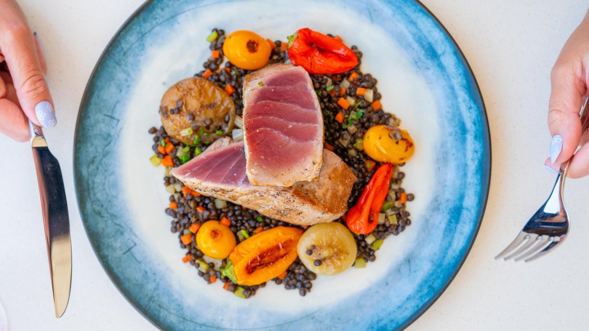 an artfully arrange plate of ahi tuna with veggies and lentils