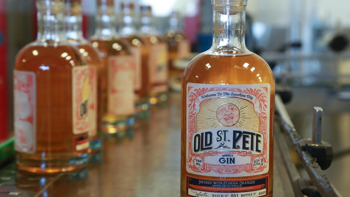 an old-fashioned looking bottle of amber-colored gin with a label that says Old St. Pete; there are other bottles behind it on the bar