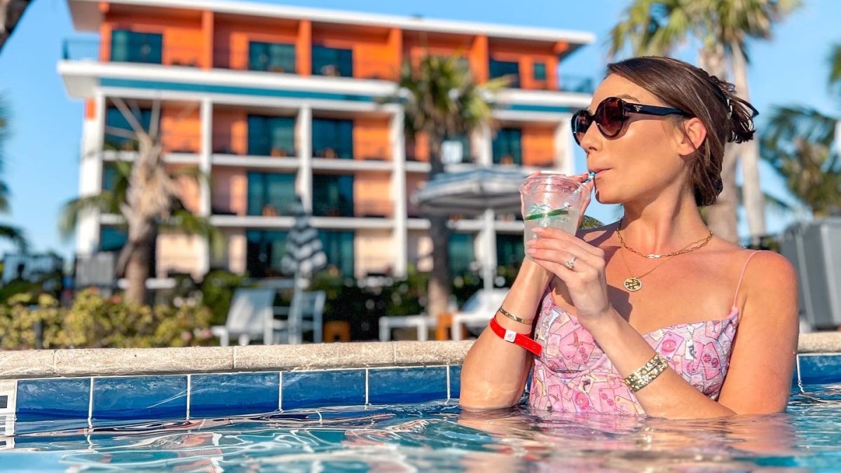 A woman relaxes in the pool of Fenway with a Cocktail