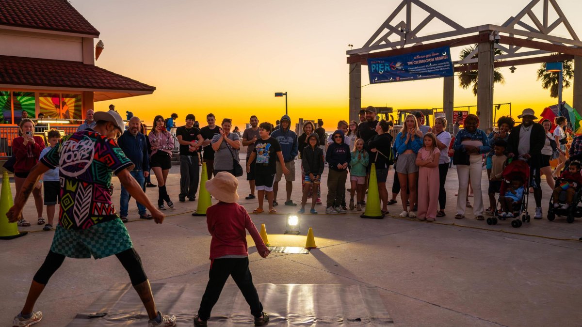 a performer engages with a small child at the sunsets at Pier 60 nightly celebration