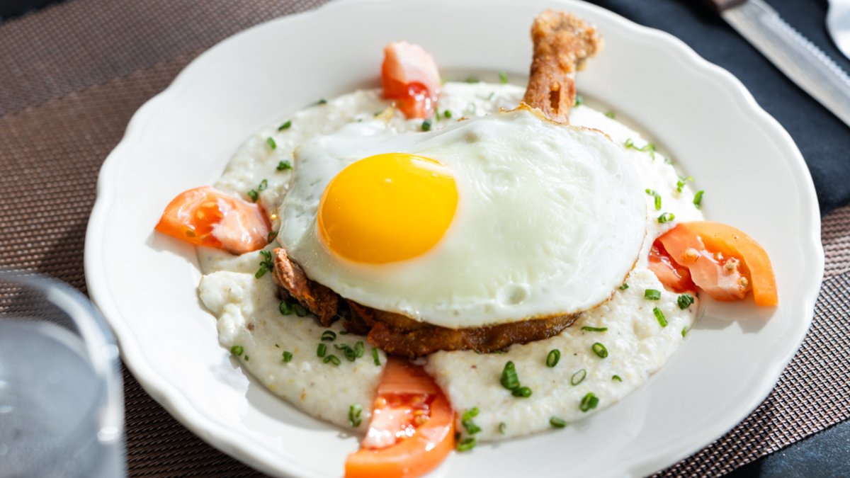A plate of duck confit topped with an egg