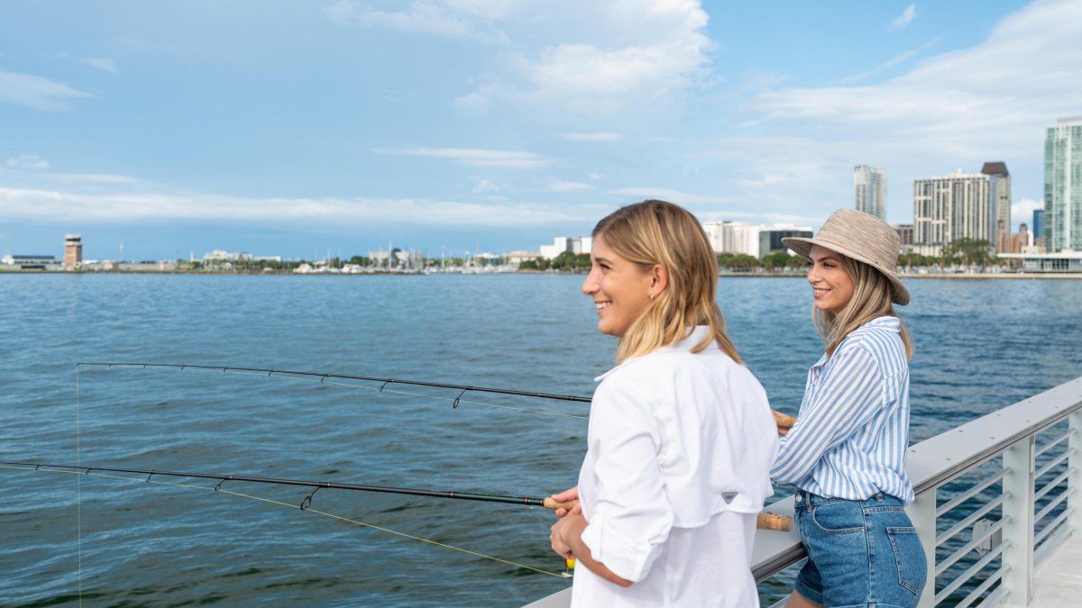 Two women fishing off a pier