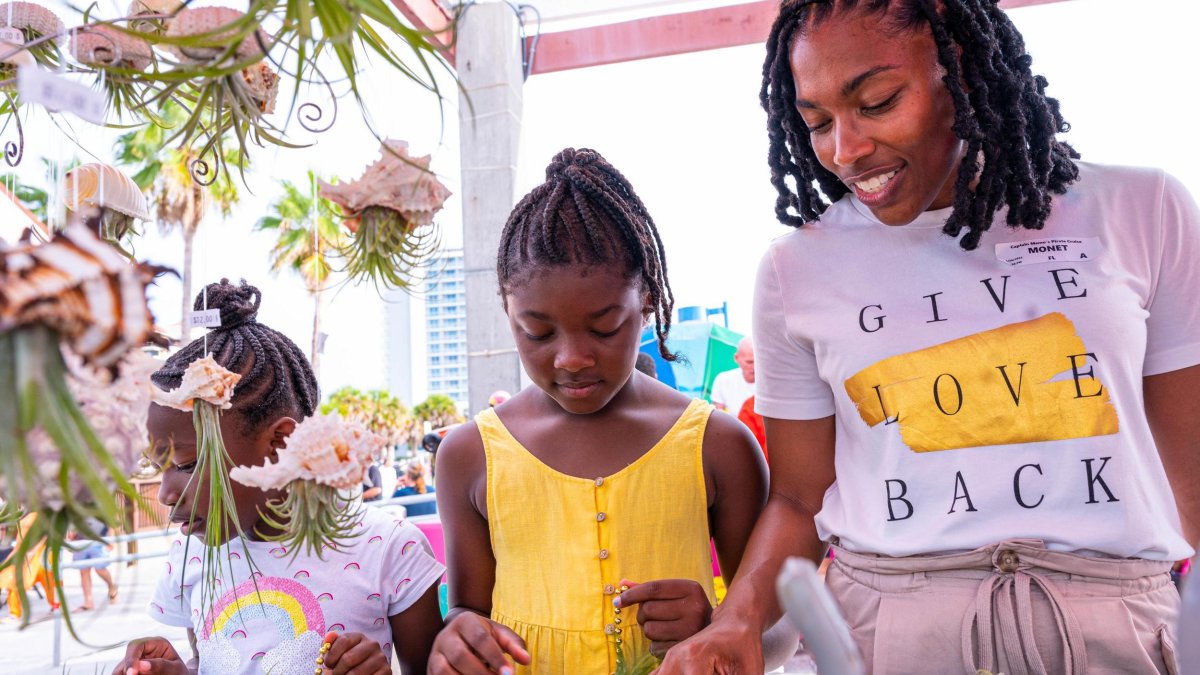 a woman and her two daughters looking at plants for sale at the Sunsets at Pier 60 celebration