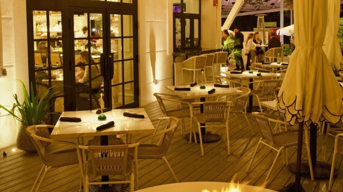 a firepit and tables and chairs on the outside deck of Perry's Porch restaurant
