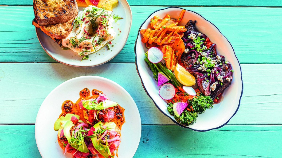 three dishes of beautifully plated food on a colorful table