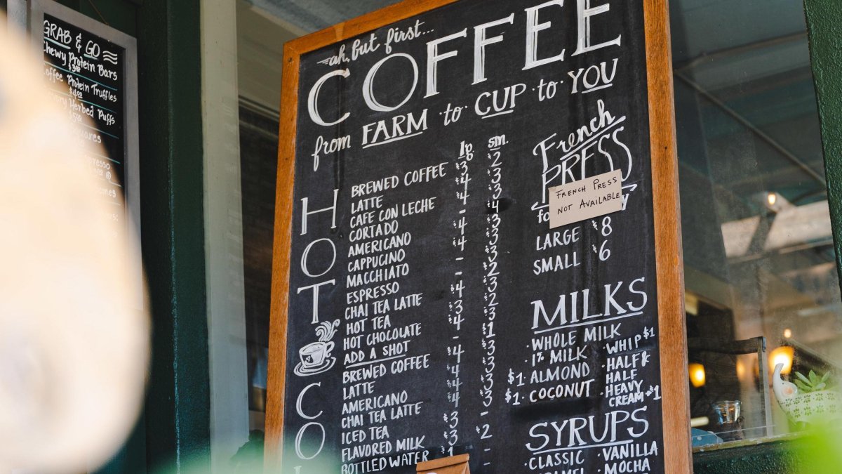 a chalkboard sign with a long list of coffee options at Cafe Vino Tinto