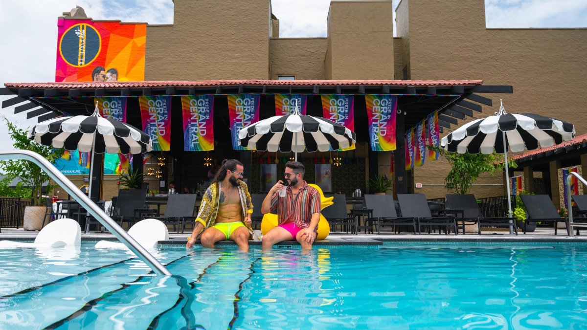 two men relax on the edge of a hotel pool at Mari Jean Hotel in St. Petersburg