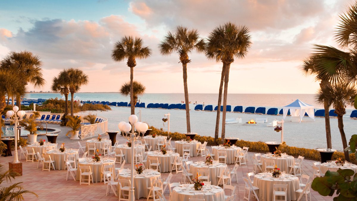 a large patio decorated for a wedding near the beach at TradeWinds Resort