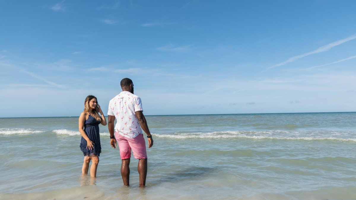 a couple wades into the Gulf waters