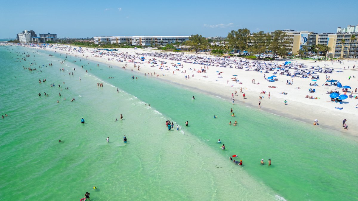 drone shot of the beach with emerald water