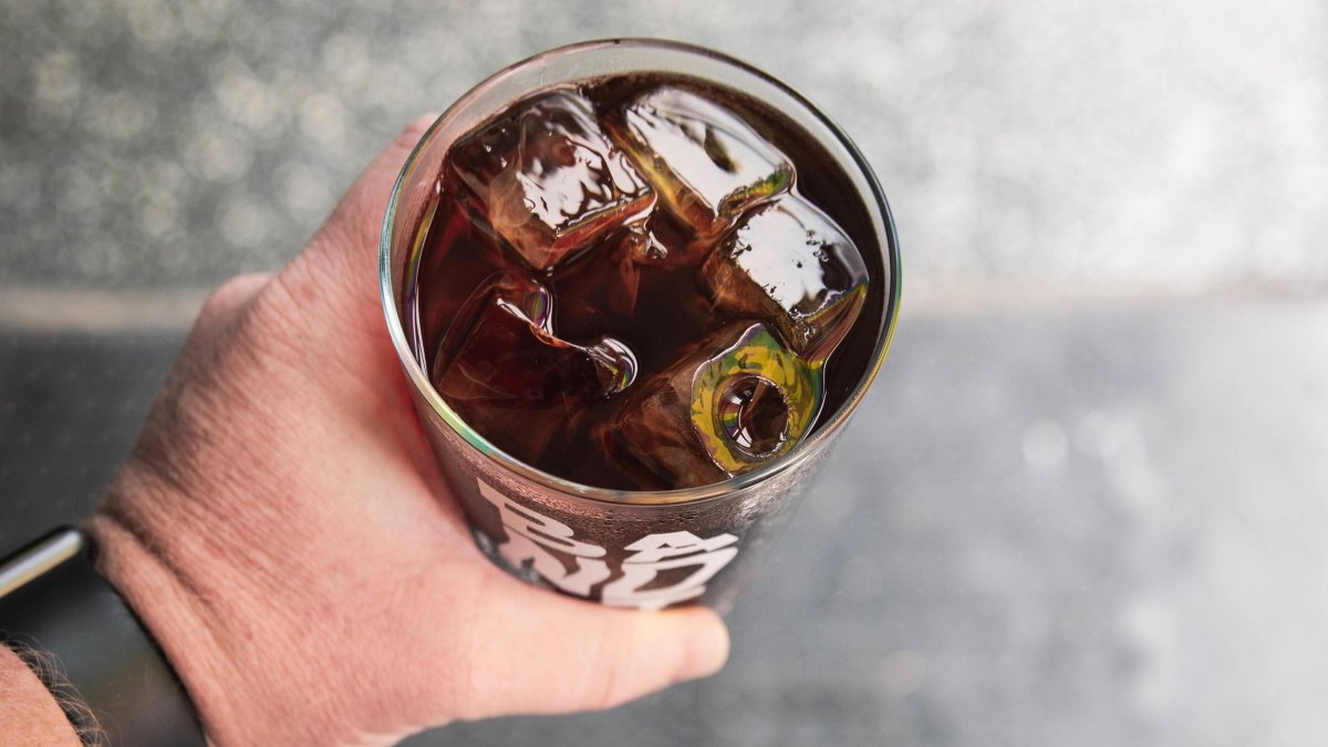 a person's hand holding a glass of iced black coffee at Bandit Coffee Co.