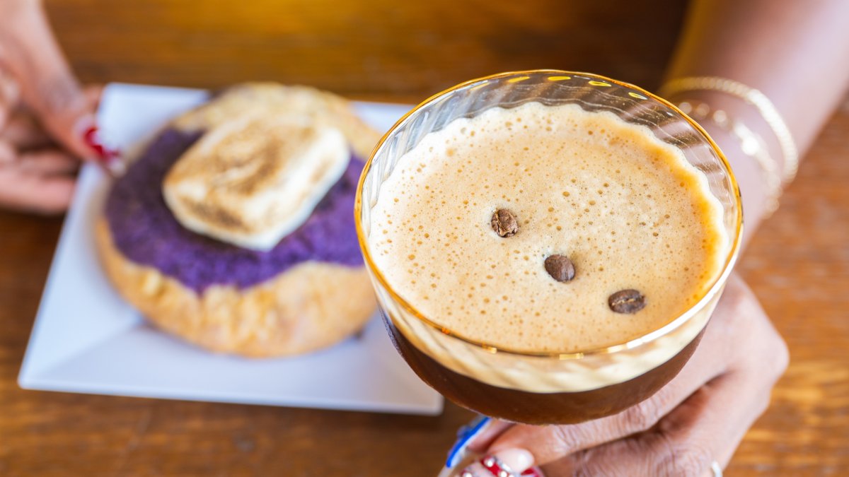 a fancy espresso drink with coffee bean on top next to a dessert at Hogg Batch Gold Bar