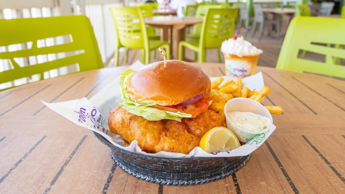 A delicious fried grouper sandwich on a brioche bun at an outside table at Crabby's Beachside Pavilion in Clearwater Beach