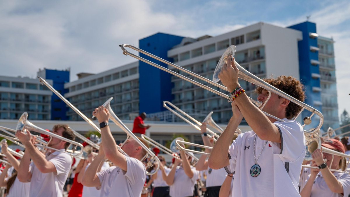 a college band playing on the beach at the Reliaquest Bowl Clearwater Beach Day