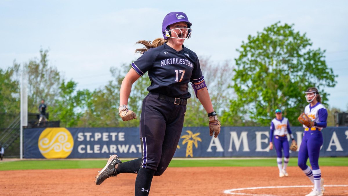 a softball player shouts as she runs the bases after a home run
