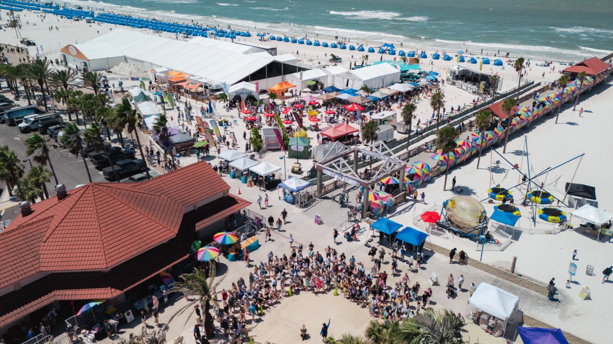 an aerial view of Clearwater Beach with a tent, entertainers and many people at the Pier 60 Sugar Sand Festival