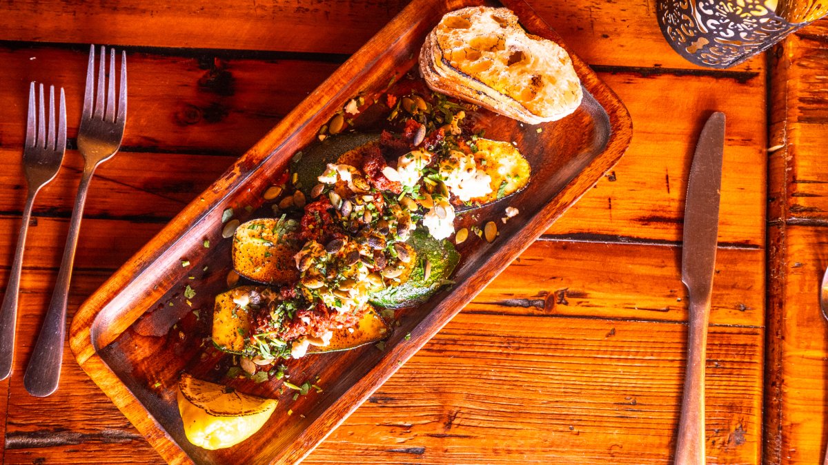 a beautiful plate of food on a rustic wooden table at Calida Kitchen + Wine in St. Petersburg