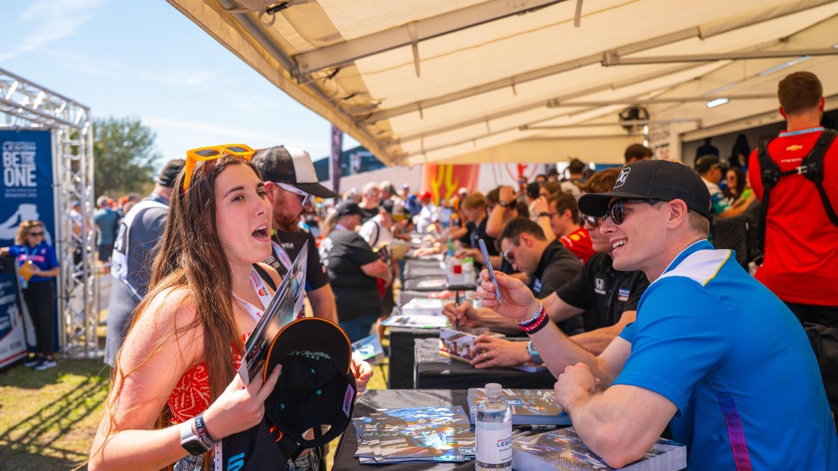 race car drivers sign autographs for fans at the Firestone Grand Prix in St. Petersburg FL