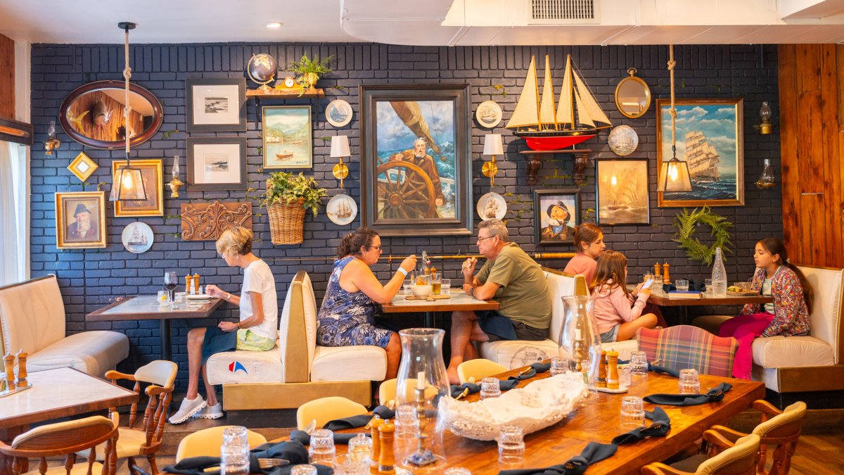 people sitting at three different booths at the nautically decorated restaurant The Helm Seafood & Provisions in St. Pete Beach