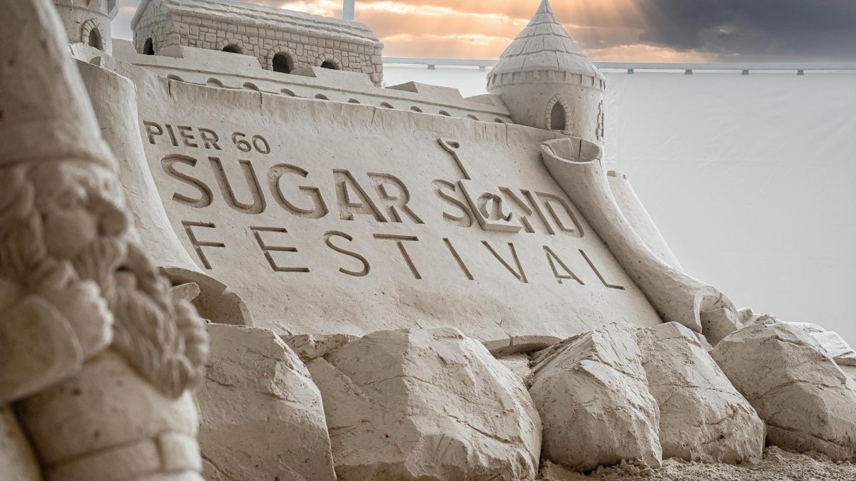 a giant sandcastle with the words Pier 60 Sugar Sand Festival carved in it