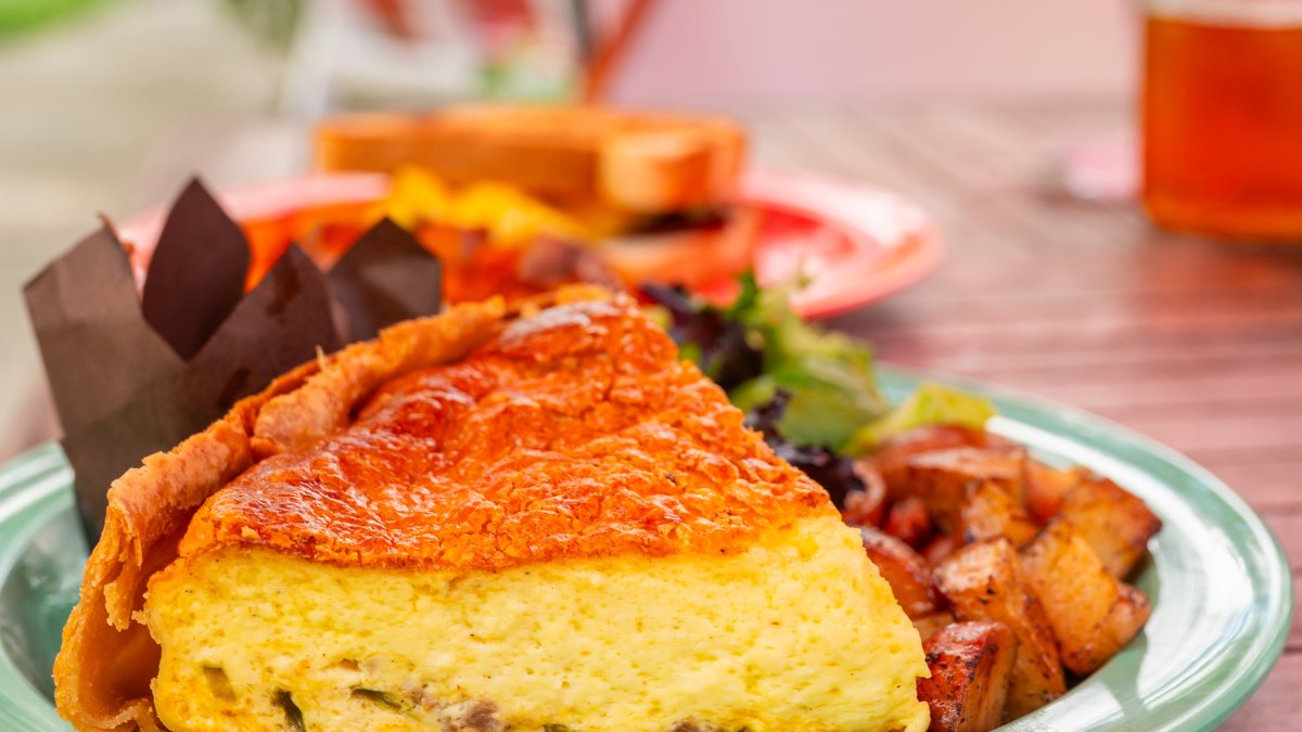 a fluffy quiche on a plate next to breakfast potatoes at Wild Iris Cafe