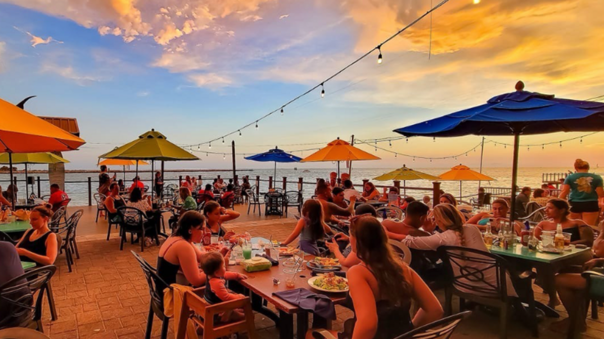 the deck at Jimmy's Fish House & Iguana Bar with people dining at sunset