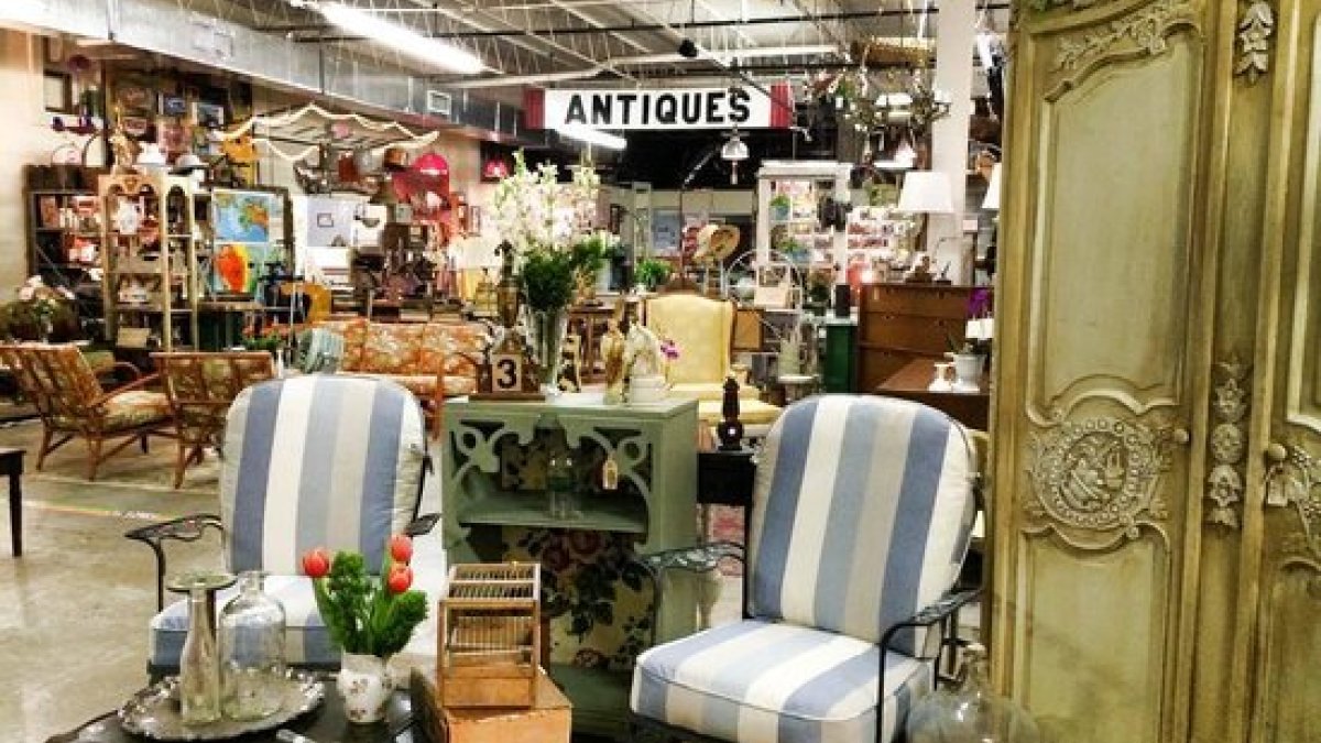 Interior of Vintage Marché filled with antique and vintage furniture, décor and collectibles, including striped chairs and an ornate cabinet.