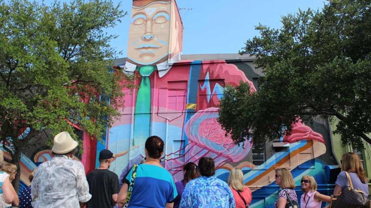 People on the street looking at a mural