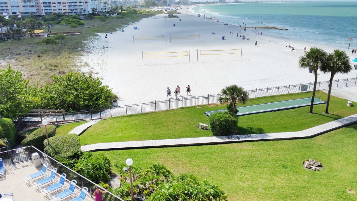 View of grassy lawn and beach at Caprice Resort