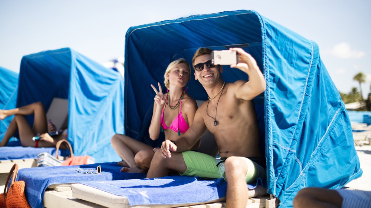 Relax on a cushioned beach cabana for two