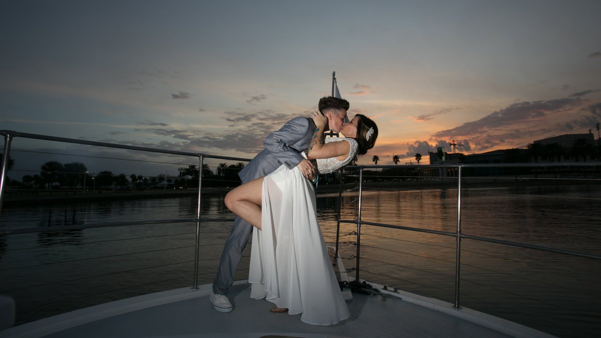 Couple kissing on bow of boat after getting married.