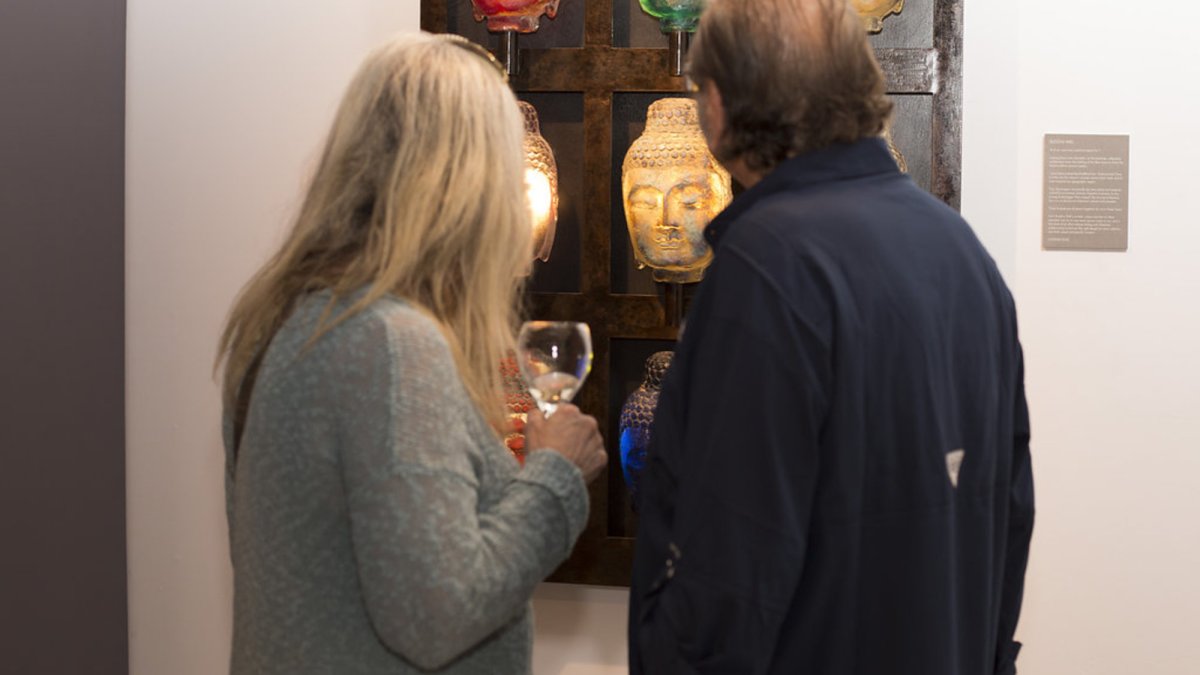 Collectors viewing Marlene's Buddha Wall Glass Sculpture