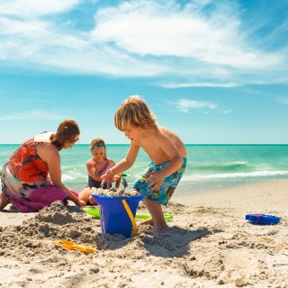 A family building a sand castle on the beach in Treasure Island.