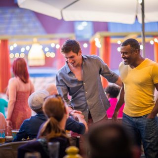 A couple men greet friends at a LGBT+ Bar and Restaurant