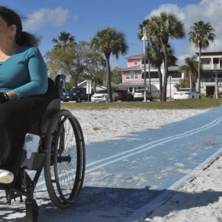 Woman in wheelchair on Mob-Mat on the beach