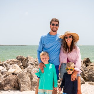 family standing on the beach