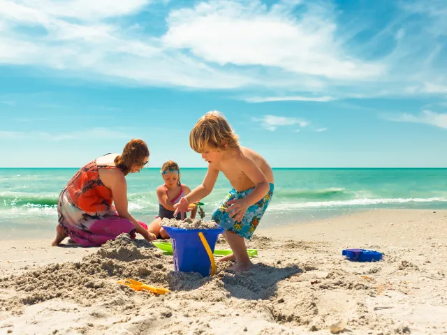 A family building a sand castle on the beach in Treasure Island.