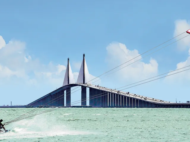 A man kiteboards at the Skyway Bridge